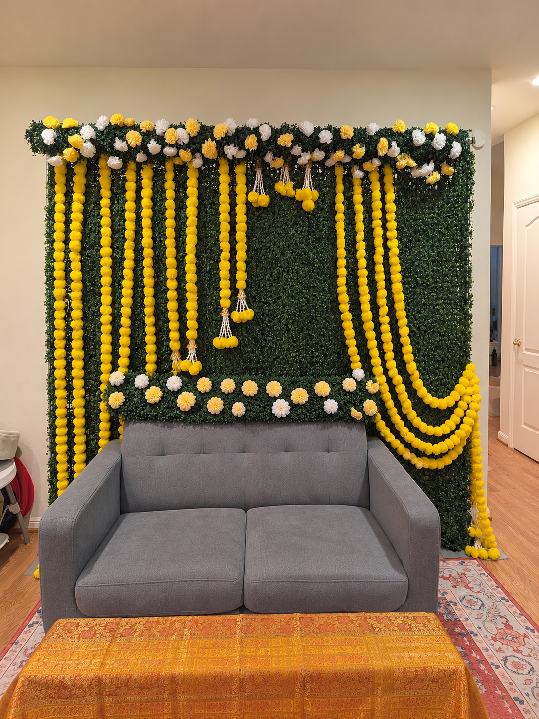 Annaprasana greenery backdrop with yellow garlands and white and yellow flowers