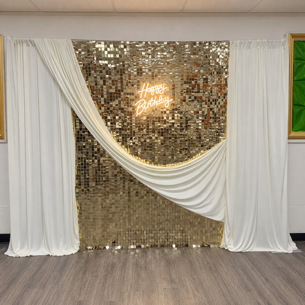 Gold shimmer birthday backdrop with white draping and a glowing Happy Birthday sign