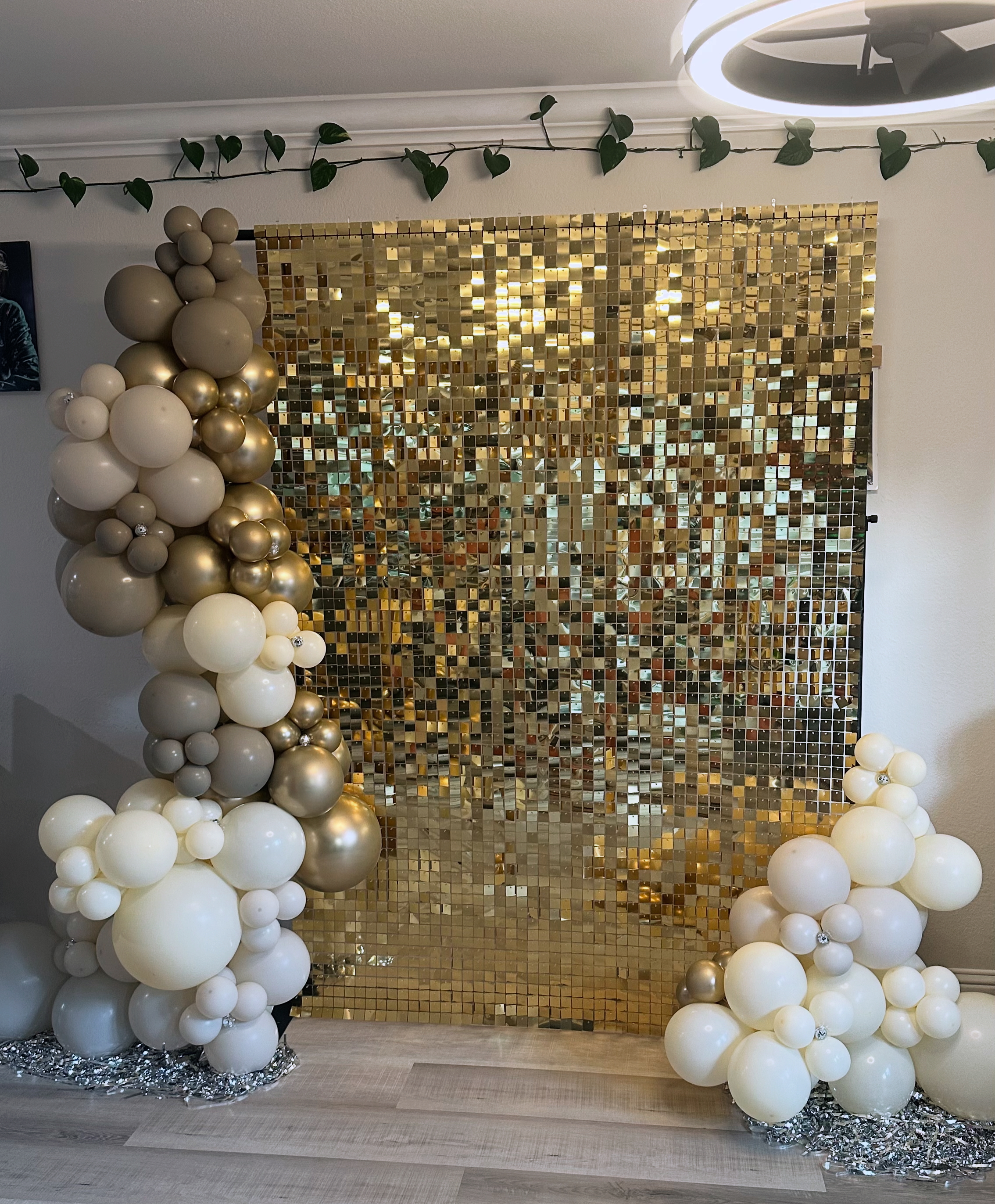 Gold shimmer backdrop with white and gold balloon decor