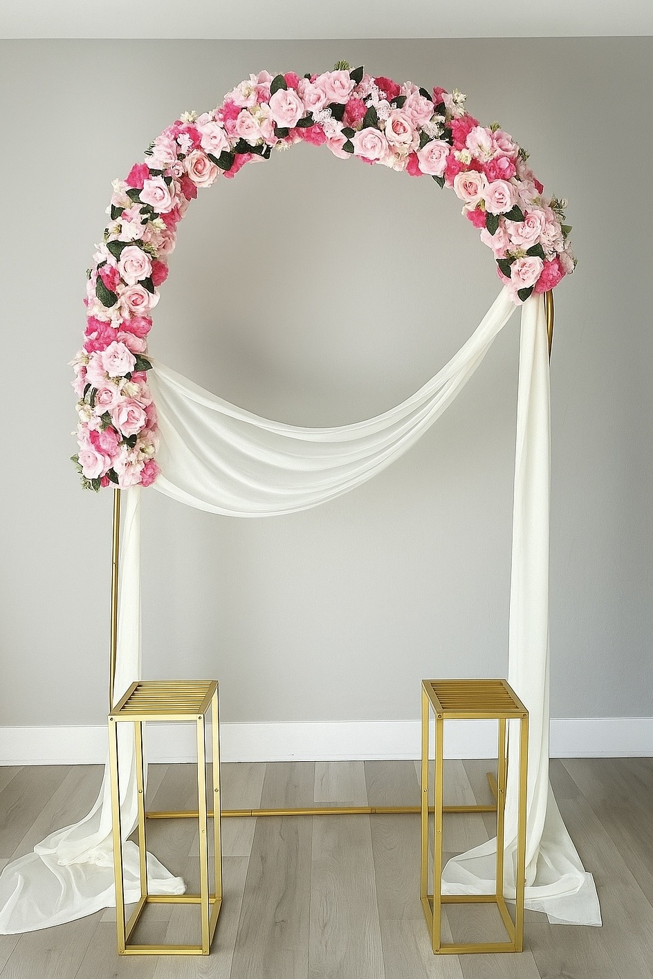 Pink floral arch with white draping